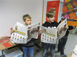 Zwei Schüler tragen aus einer Zeitung vor.